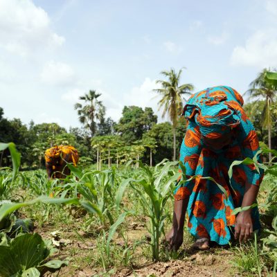 Two African Women In Traditional Dresses Cleaning Up An Extremel